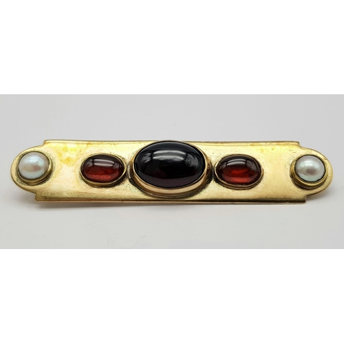 813 - AN EDWARDIAN 15K GOLD BAR BROOCH WITH SEED PEARLS , CARNELIAN AND CENTRAL GARNET  .  9.4gms   6cms w... 