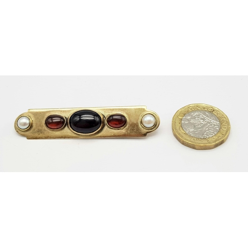 813 - AN EDWARDIAN 15K GOLD BAR BROOCH WITH SEED PEARLS , CARNELIAN AND CENTRAL GARNET  .  9.4gms   6cms w... 