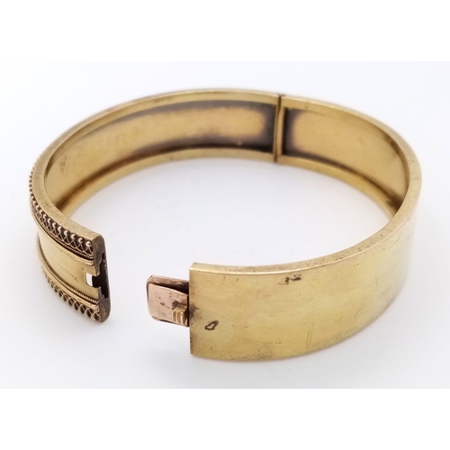 713 - A 9K GOLD BACK AND FRONT HINGED BANGLE .   13.4gms