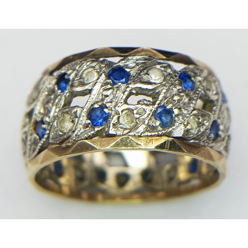 750 - A 9K WHITE AND YELLOW GOLD BAND RING WITH PIERCED SIDES AND CONTAINING A SAPPHIRE AND DIAMOND PATTER... 