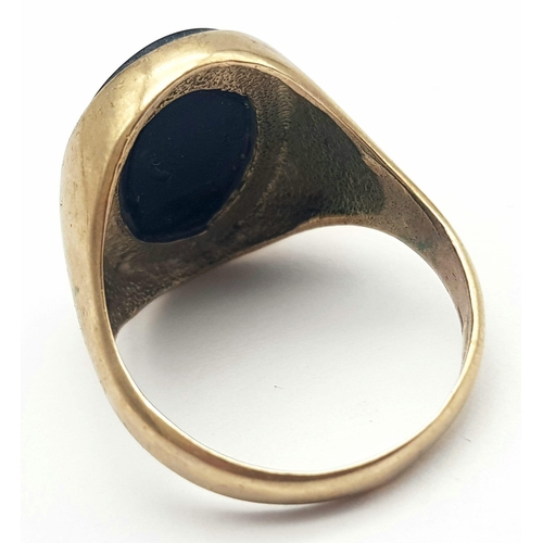 793 - A GENTS 9K GOLD SIGNET RING WITH BLACK ONYX OVAL STONE .    6.6gms   size T