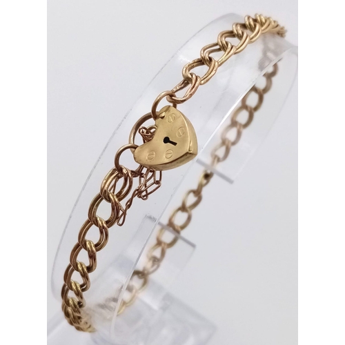 811 - A 9K GOLD INTERLINK BRACELET WITH HEART PADLOCK AND SAFETY CHAIN .   3.6gms   18cms