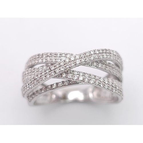 865 - A 9K White Gold Diamond Encrusted Orbital Ring. Eight lines of bright small round cut diamonds. Size... 