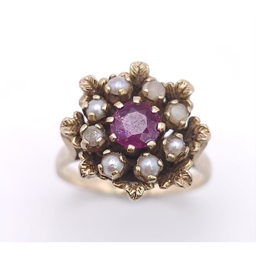 575 - A vintage, 9 K yellow gold ring with a round cut ruby surrounded by pearls. Size: K, weight: 4.5 g.