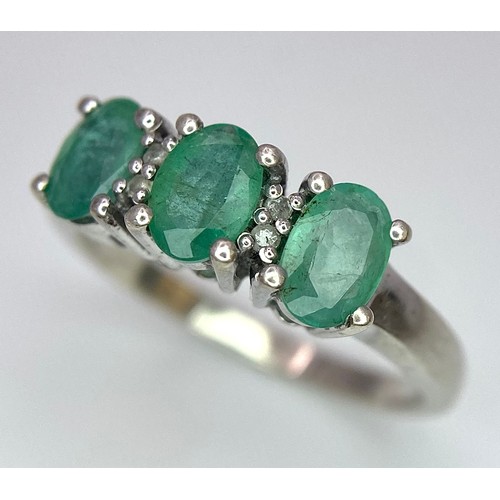 888 - A Sterling Silver Three Emerald and Four Diamond Ring Size P. Set three oval cut 7mm Emeralds and fo... 