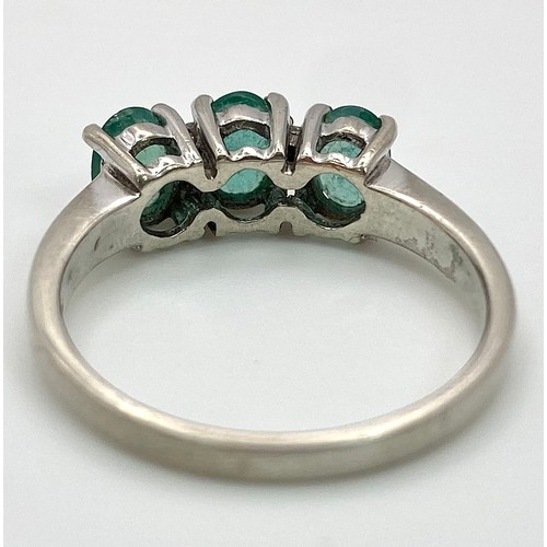 888 - A Sterling Silver Three Emerald and Four Diamond Ring Size P. Set three oval cut 7mm Emeralds and fo... 