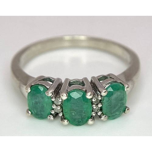 888 - A Sterling Silver Three Emerald and Four Diamond Ring Size P. Set three oval cut 7mm Emeralds and fo... 