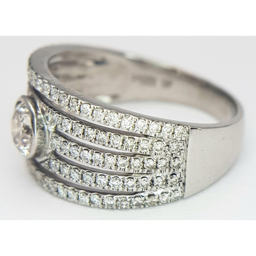 599 - An 18K White Gold Diamond Supreme Half Eternity Ring. O.527ct brilliant round cut central diamond wi... 