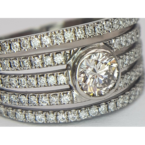 599 - An 18K White Gold Diamond Supreme Half Eternity Ring. O.527ct brilliant round cut central diamond wi... 