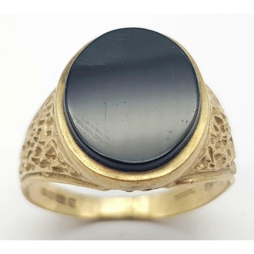 655 - A GENTS SIGNET RING WITH BLACK ONYX STONE AND BARKED SHOULDERS .  4.4gms   size Q