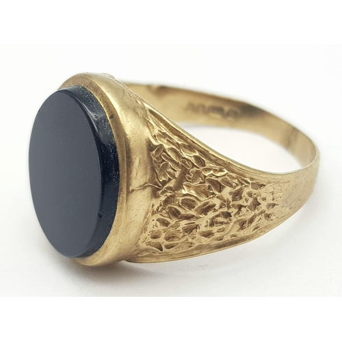 655 - A GENTS SIGNET RING WITH BLACK ONYX STONE AND BARKED SHOULDERS .  4.4gms   size Q