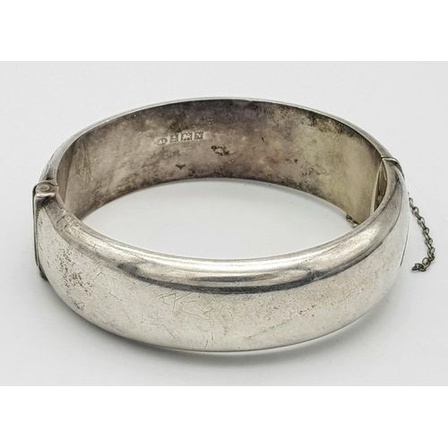 1297 - A Vintage Sterling Silver Bangle. Birmingham hallmarks. Clip open. 6cm inner diameter. 30g weight.