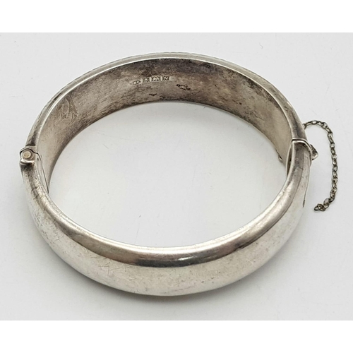 1297 - A Vintage Sterling Silver Bangle. Birmingham hallmarks. Clip open. 6cm inner diameter. 30g weight.