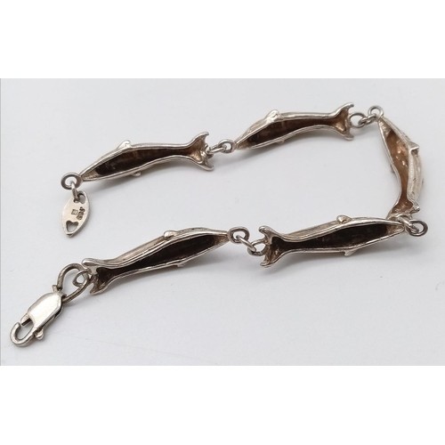 418 - A Sterling Silver Dolphin bracelet. 
6cm in diameter. 
Weight: 12.66g