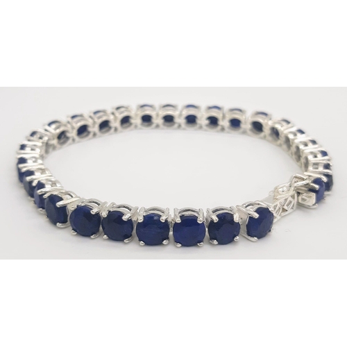 400 - A Blue Sapphire Gemstone Tennis Bracelet set in 925 Silver.
18cm length. 19.75g total weight. Ref: C... 