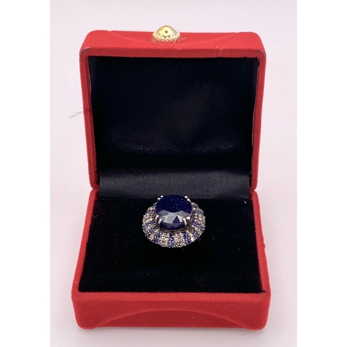 436 - A 13ct Blue Oval Cut Sapphire Ring with 0.90ctw Blue Sapphires and 0.90ctw Diamond accents. Set in 9... 