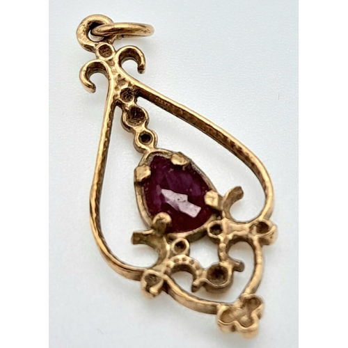 292 - An Art Deco Style 9K Gold and Ruby Pendant. 25mm. 1g total weight.