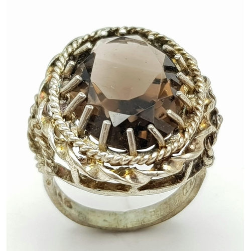 71 - A vintage large smoky quartz faceted stone set ring on crown mount, with lovely scroll work on shoul... 