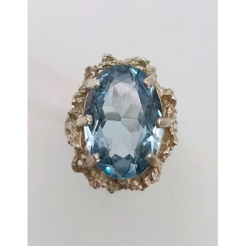 94 - A large faceted oval blue topaz stone set silver ring, weight 5.78g and size M