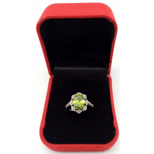 11 - A Peridot and Diamond 925 Silver Ring. Central 2.50ct oval peridot with a diamond surround - 0.20ctw... 