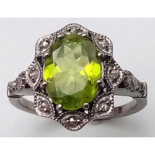 11 - A Peridot and Diamond 925 Silver Ring. Central 2.50ct oval peridot with a diamond surround - 0.20ctw... 