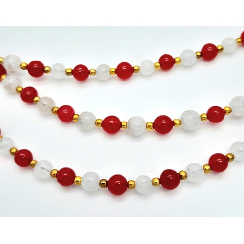 207 - A very elegant, three row necklace with alternating rubies and moonstones, adorned with an ornamenta... 