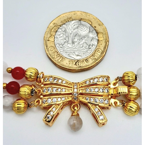 207 - A very elegant, three row necklace with alternating rubies and moonstones, adorned with an ornamenta... 