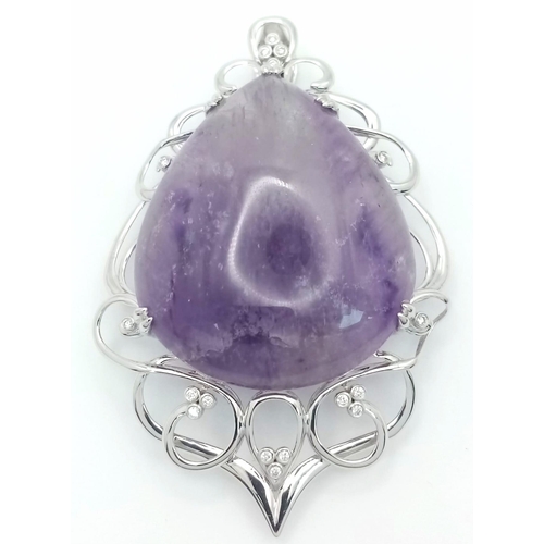 186 - A 9 K white gold pendant with a large pear shaped amethyst cabochon (80.36 carats) set on an ART NOU... 