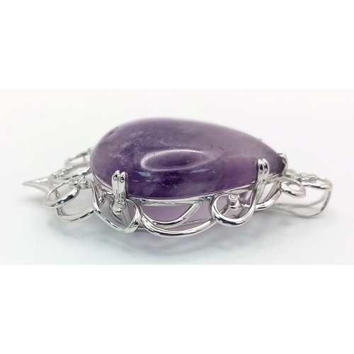 186 - A 9 K white gold pendant with a large pear shaped amethyst cabochon (80.36 carats) set on an ART NOU... 