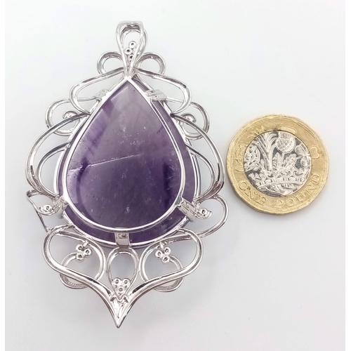 186 - A 9 K white gold pendant with a large pear shaped amethyst cabochon (80.36 carats) set on an ART NOU... 