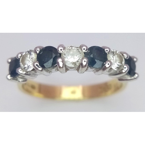 227 - An 18 K yellow gold ring with a band of alternating round cut diamonds and blue sapphires. Size: K, ... 