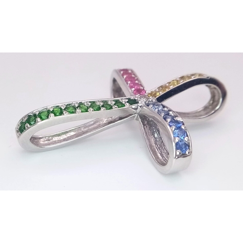 247 - A highly unusual 14 K white gold cross studded with emeralds, rubies citrine and sapphires. Dimensio... 