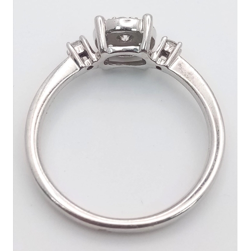 261 - A 9 K white gold ring with a diamond cluster and a single diamond at the top of each shoulder, size:... 