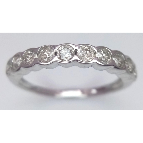 268 - An 18 K white gold ring with a band of round cut diamonds, size: L1/2, weight: 1.9 g.