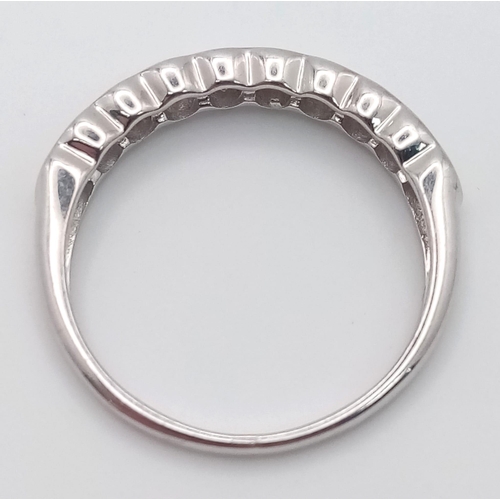 268 - An 18 K white gold ring with a band of round cut diamonds, size: L1/2, weight: 1.9 g.