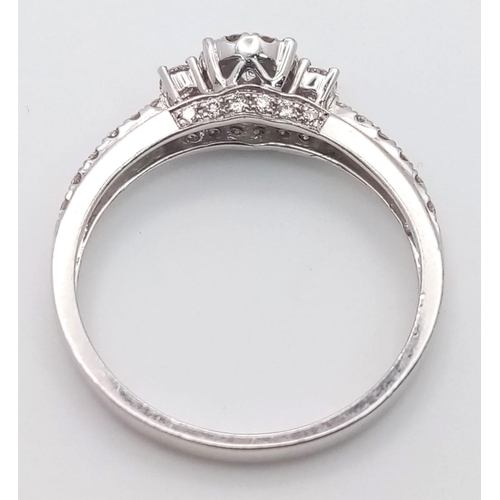 318 - A 9 K white gold ring with a diamond cluster and more diamonds on the shoulders (total 0.41 carats),... 