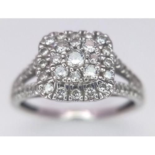 368 - A 9 K white gold ring with a diamond cluster and more diamonds on the shoulders of the ring, size: N... 