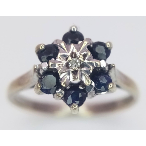 424 - A 9 K yellow gold ring with a single diamond surrounded by six blue sapphires, size: M1/2, weight: 2... 