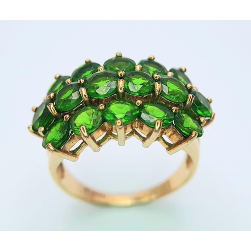 472 - A 9 K yellow gold ring with a cluster of round cut peridots arranged over three rows. Size: L, weigh... 