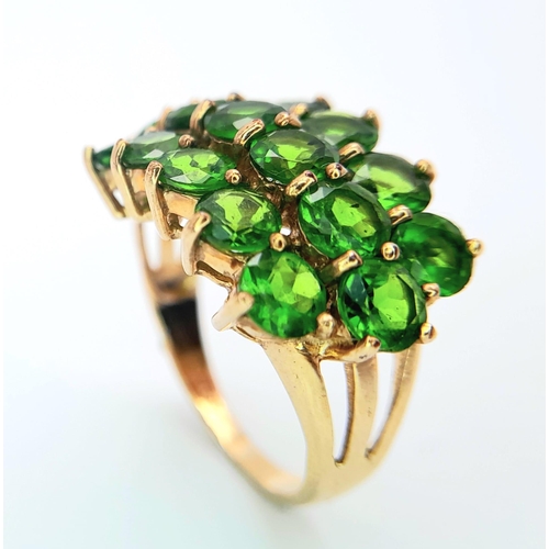 472 - A 9 K yellow gold ring with a cluster of round cut peridots arranged over three rows. Size: L, weigh... 