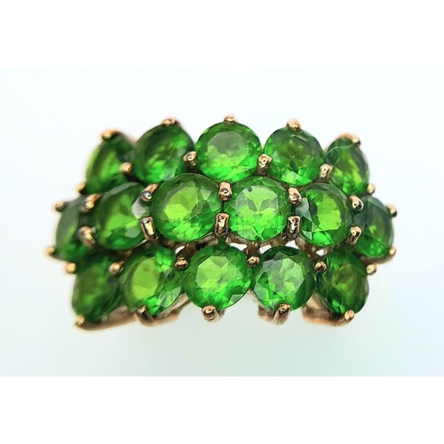 472 - A 9 K yellow gold ring with a cluster of round cut peridots arranged over three rows. Size: L, weigh... 