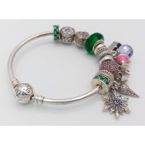 479 - A very desirable ,sterling silver PANDORA bangle with thirteen charms, total weight: 45 g.