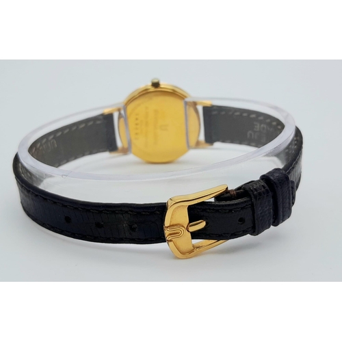 354 - A Gold Plated Universal Quartz Ladies Watch. Black leather strap. Gold plated case - 23mm. White dia... 