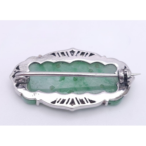 554 - AN ART DECO JADE AND DIAMOND BROOCH SET IN PLATINUM .   6.7gms    3.5cms       15098