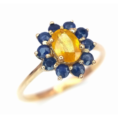 170 - A 9K GOLD RING HAVING A CENTRAL CITRINE SURROUNDED BY A HALO OF SAPPHIRES .   2.2gms   size N