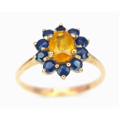 170 - A 9K GOLD RING HAVING A CENTRAL CITRINE SURROUNDED BY A HALO OF SAPPHIRES .   2.2gms   size N