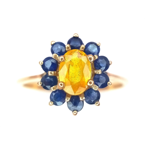 170 - A 9K GOLD RING HAVING A CENTRAL CITRINE SURROUNDED BY A HALO OF SAPPHIRES .   2.2gms   size N