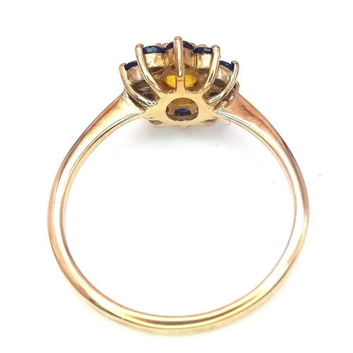 170 - A 9K GOLD RING HAVING A CENTRAL CITRINE SURROUNDED BY A HALO OF SAPPHIRES .   2.2gms   size N