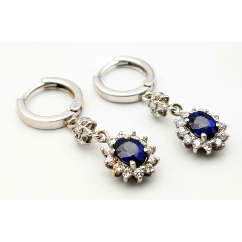 295 - An 18K White Gold, Diamond and Sapphire Jewellery Set. Oval cut sapphire with diamond surround on an... 