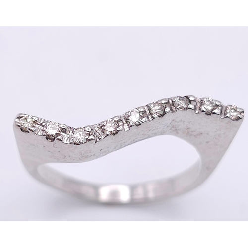 303 - An 18K White Gold Diamond Wave Ring. Nine diamonds on the crest of a wave. Size M. 5.43g total weigh... 